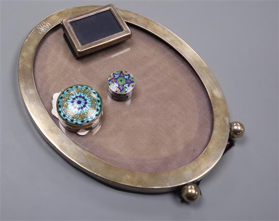 A sterling oval easel photograph frame on bun feet, a small silver frame and two miniature silver and enamel boxes